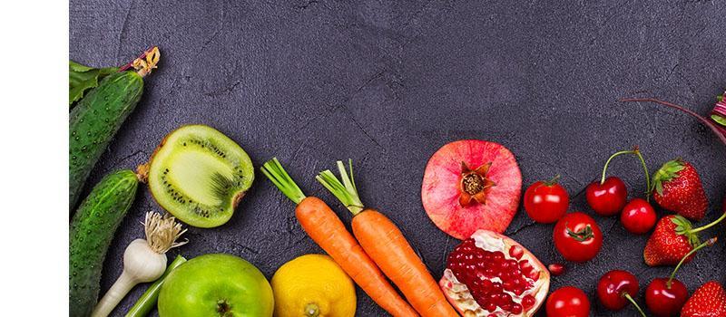 Verschiedenes Obst und Gemüse auf dunklem Hintergrund