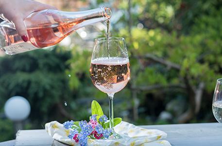 Roséwein eingeschenkt im Garten