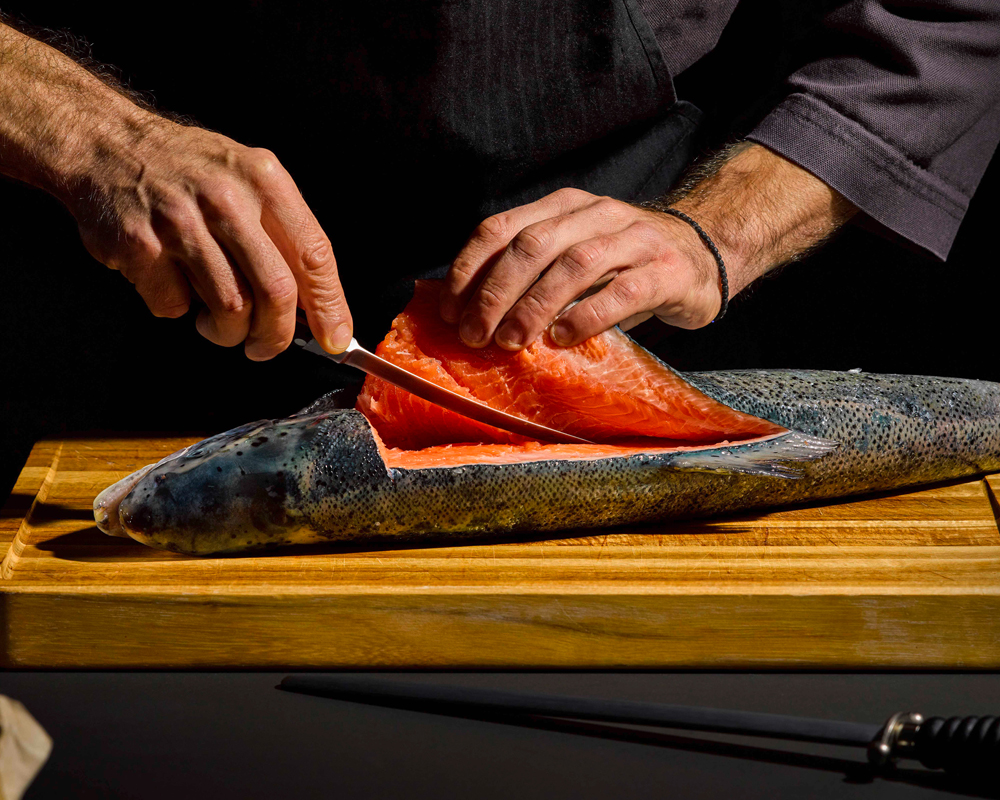 Fisch schneiden auf Schneidebrett in Küche